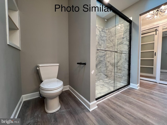 bathroom featuring toilet, a shower with shower door, and hardwood / wood-style flooring