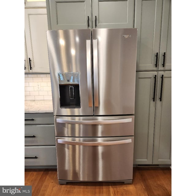 kitchen featuring light stone counters, hardwood / wood-style flooring, gray cabinets, and stainless steel refrigerator with ice dispenser