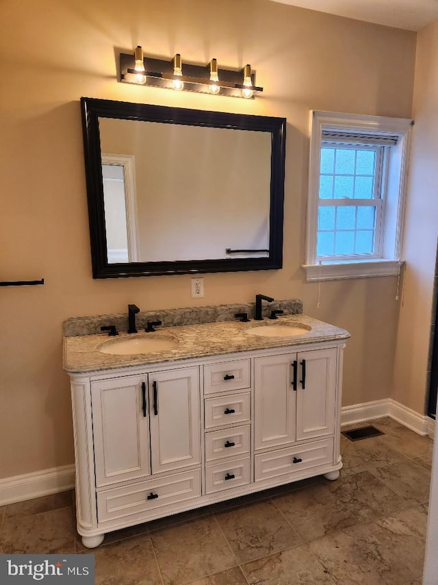 bathroom with tile patterned floors and dual bowl vanity