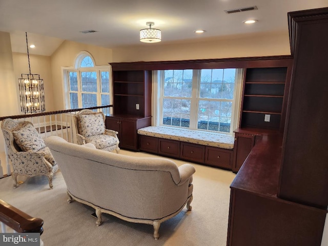 living room with an inviting chandelier, a wealth of natural light, and light colored carpet