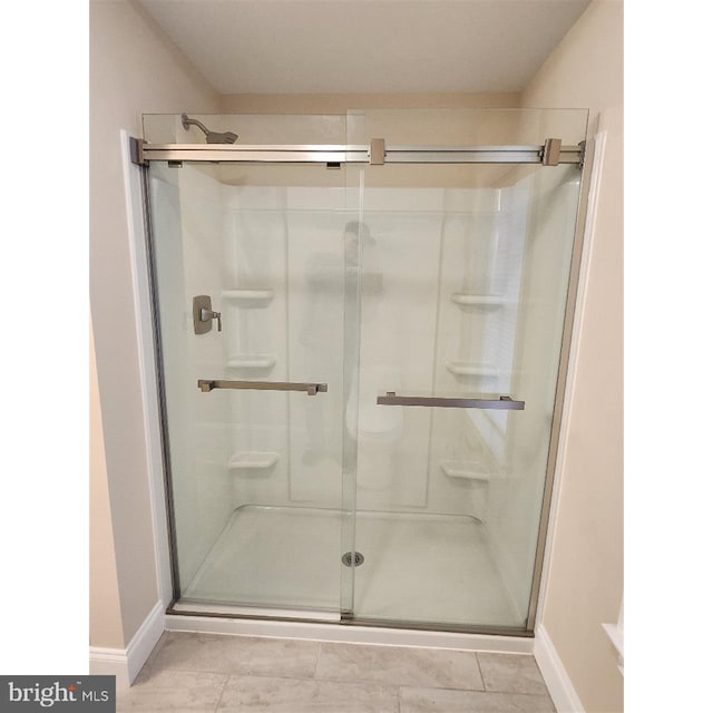 bathroom featuring a shower with shower door and tile patterned floors