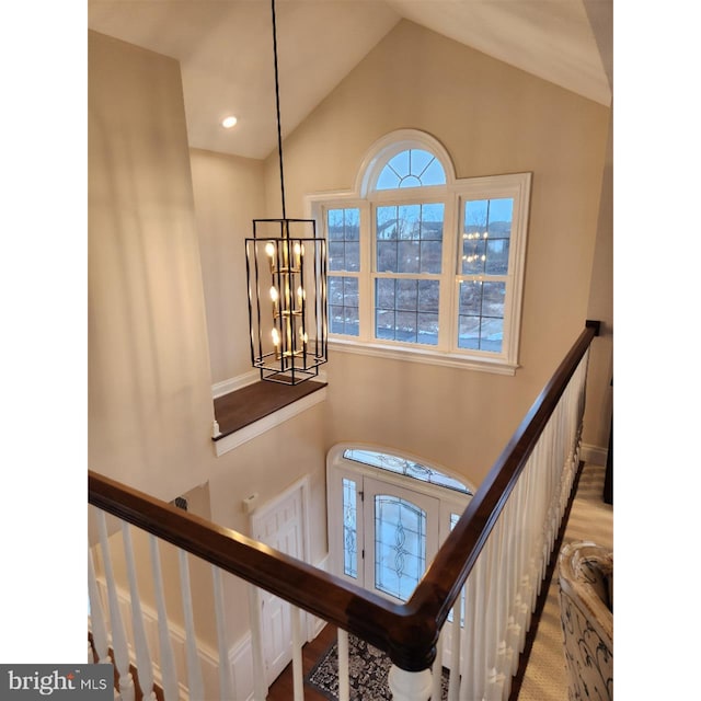 stairway featuring an inviting chandelier and lofted ceiling