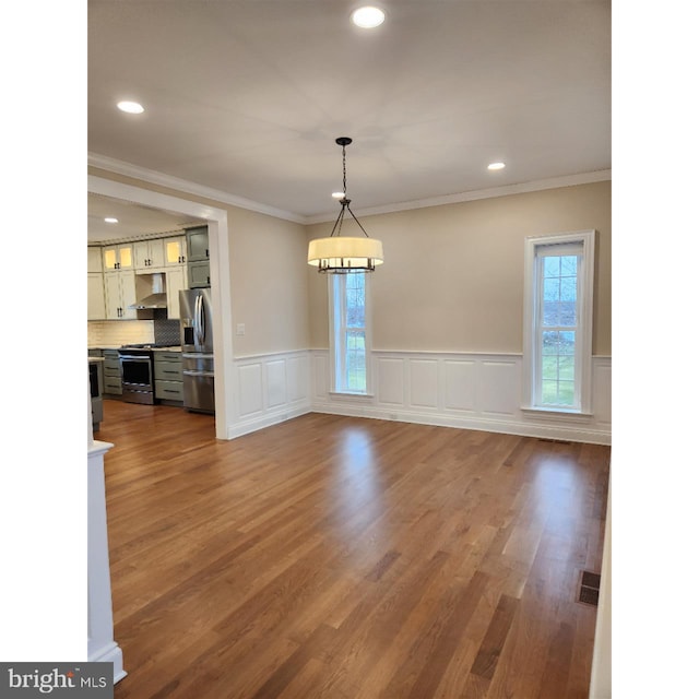 unfurnished living room with hardwood / wood-style flooring and ornamental molding