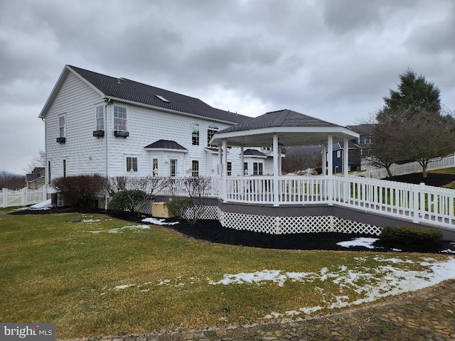 back of property with a yard and a wooden deck