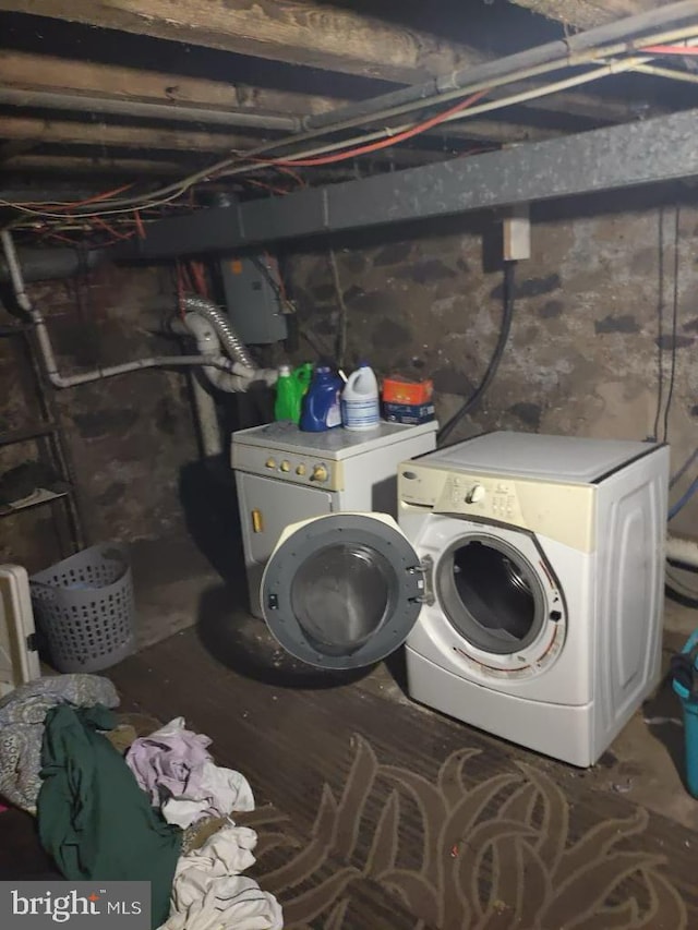 clothes washing area with washing machine and dryer and electric panel