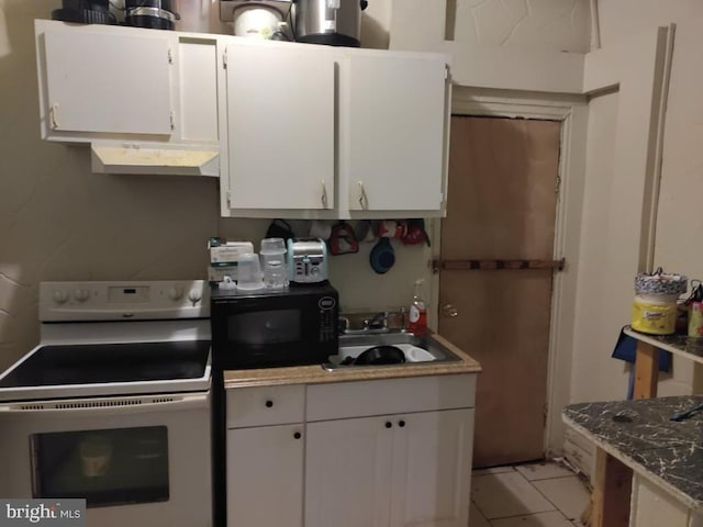 kitchen featuring stone countertops, white cabinetry, electric stove, and sink