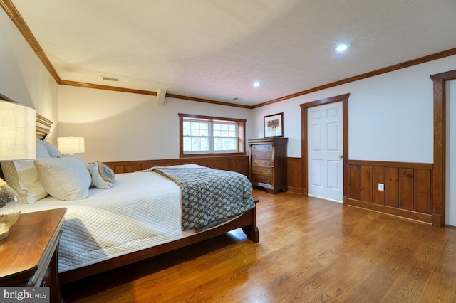 bedroom with hardwood / wood-style floors and crown molding