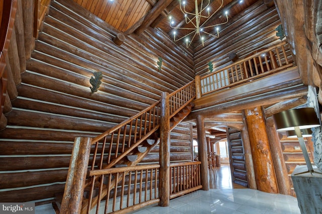 wine area with rustic walls, beamed ceiling, a notable chandelier, a towering ceiling, and wood ceiling