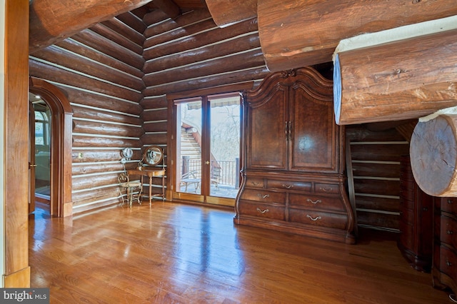 interior space featuring hardwood / wood-style floors, access to exterior, and log walls