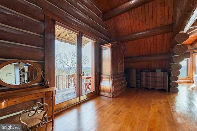 interior space with hardwood / wood-style floors, lofted ceiling with beams, wood ceiling, and log walls