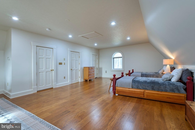 bedroom with hardwood / wood-style floors and vaulted ceiling