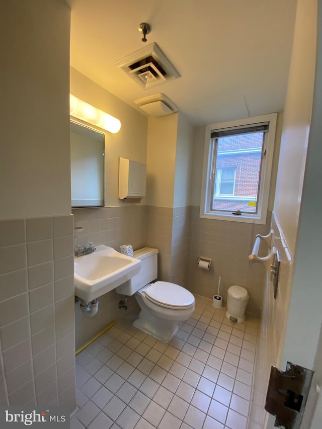 bathroom with backsplash, toilet, tile walls, tile patterned floors, and sink