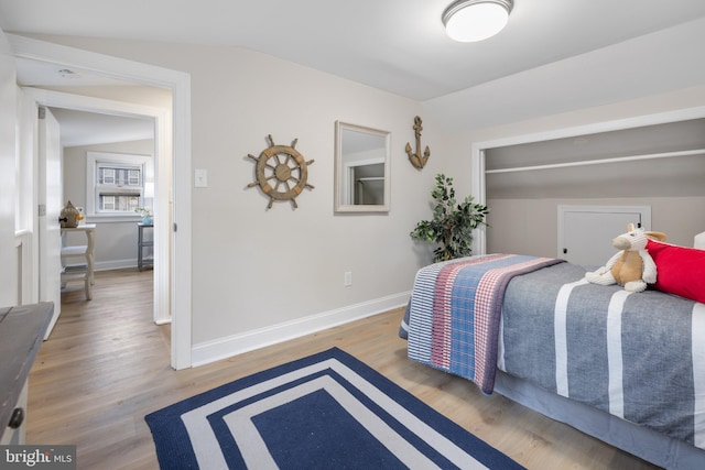 bedroom featuring light hardwood / wood-style floors and vaulted ceiling