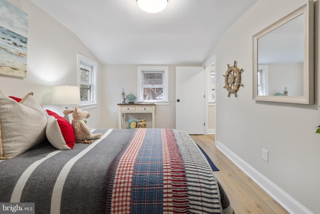 bedroom featuring light hardwood / wood-style floors and lofted ceiling