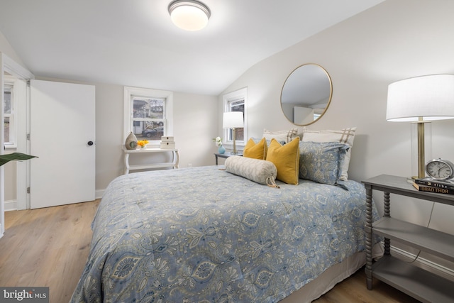 bedroom with light hardwood / wood-style flooring and lofted ceiling