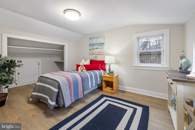 bedroom with light hardwood / wood-style floors and lofted ceiling