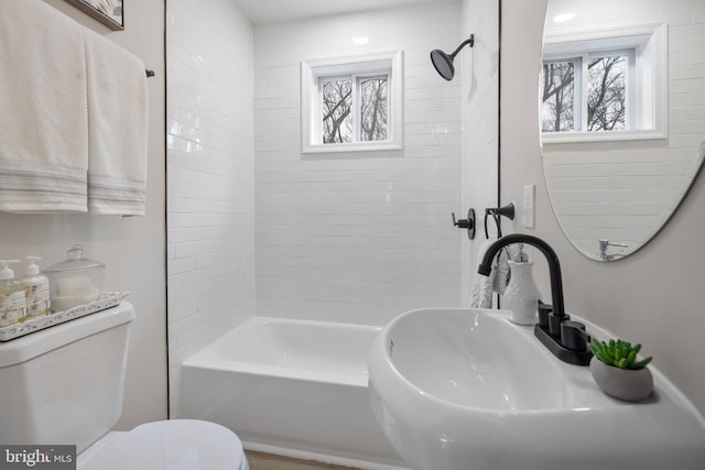 full bathroom featuring toilet, tiled shower / bath, and sink