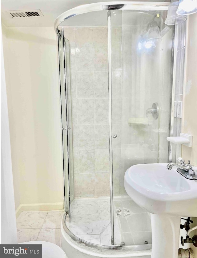 bathroom with tile flooring and a shower with door