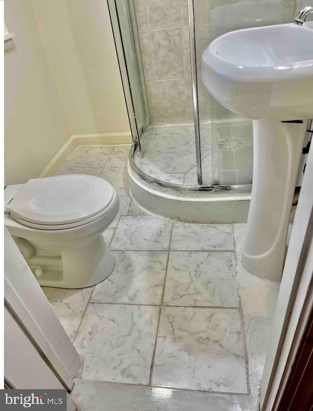 bathroom with toilet, tile flooring, and a shower with shower door