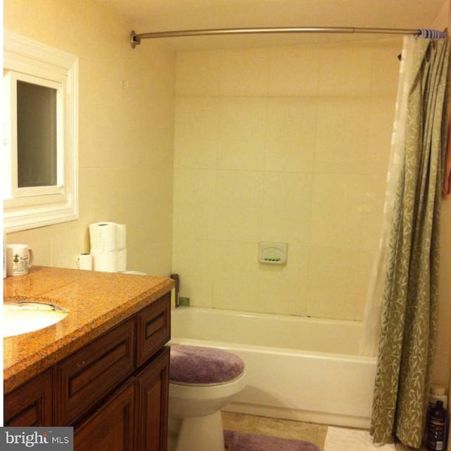 full bathroom featuring vanity, shower / bath combo with shower curtain, and toilet