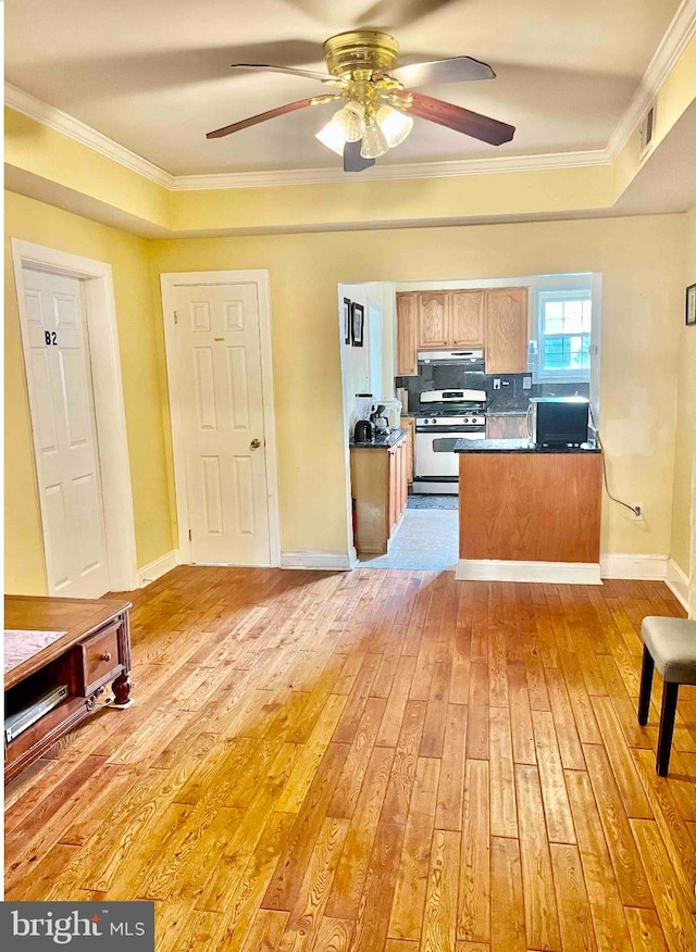 kitchen featuring tasteful backsplash, crown molding, light wood-type flooring, gas range, and ceiling fan