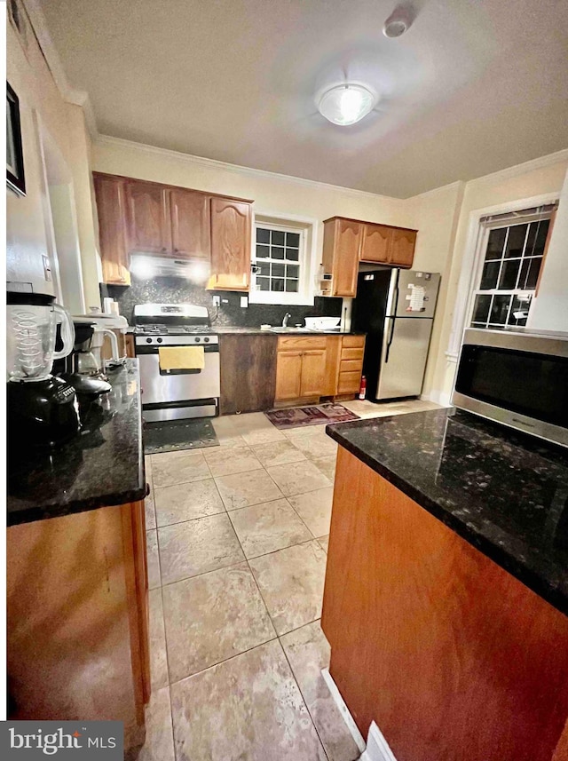 kitchen featuring dark stone counters, tasteful backsplash, light tile floors, and stainless steel appliances