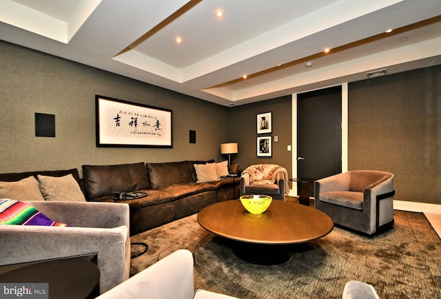 carpeted living room with a tray ceiling