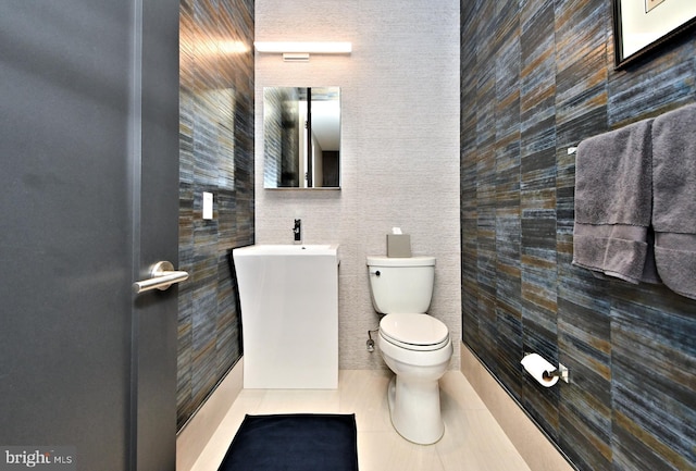 bathroom featuring sink, tile patterned flooring, tile walls, and toilet