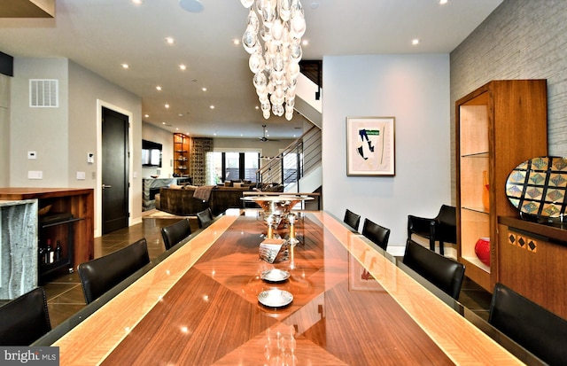 tiled dining area with ceiling fan with notable chandelier