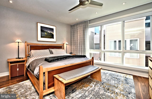 bedroom with dark hardwood / wood-style flooring and ceiling fan