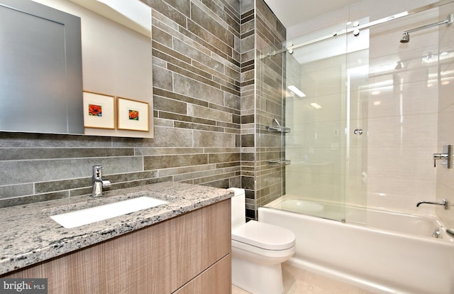 full bathroom featuring vanity, toilet, tiled shower / bath, and tasteful backsplash