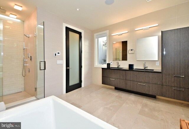 bathroom featuring tile walls, vanity, and an enclosed shower