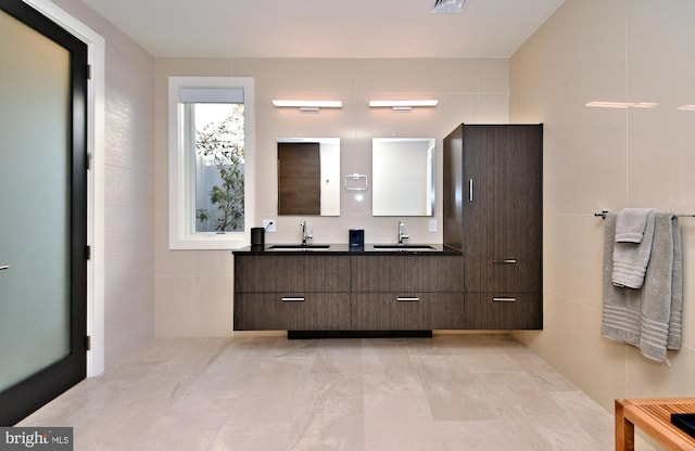 bathroom with vanity and tile walls