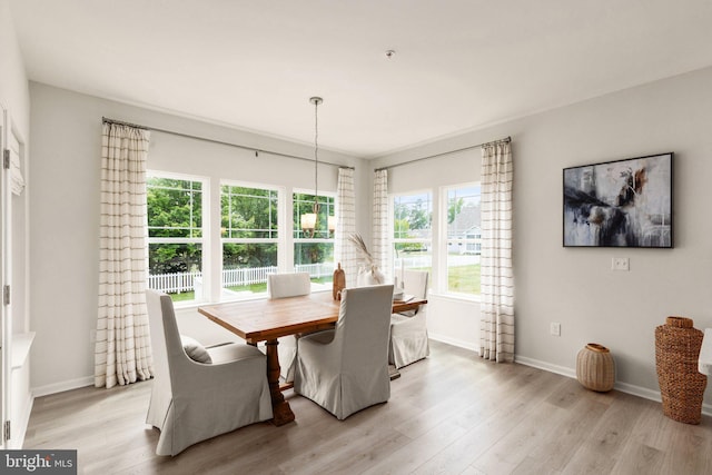 dining space with light wood finished floors and baseboards