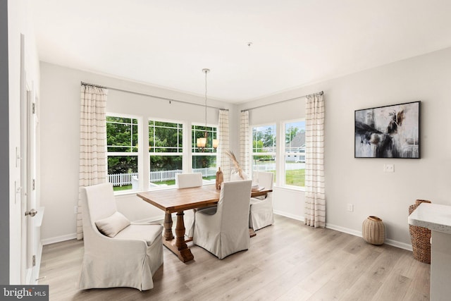 dining space featuring light wood finished floors and baseboards