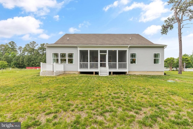 back of property with a yard, a shingled roof, and a sunroom