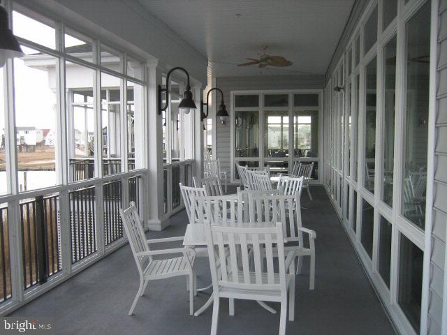 sunroom / solarium featuring a ceiling fan