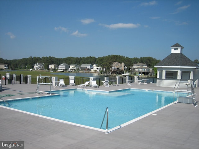 pool with a patio area and fence