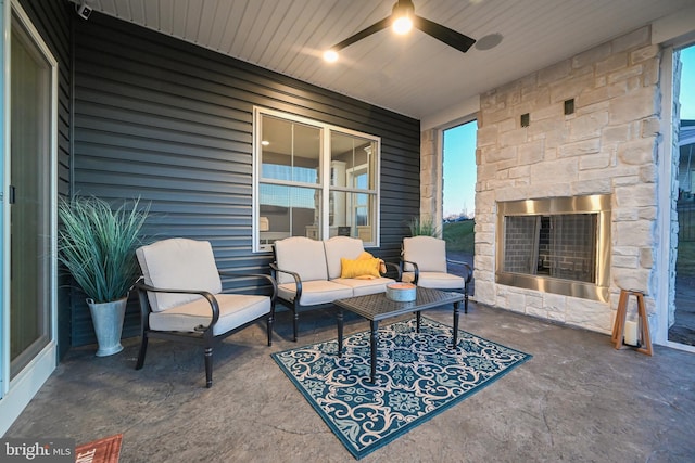 view of patio with an outdoor living space with a fireplace and ceiling fan