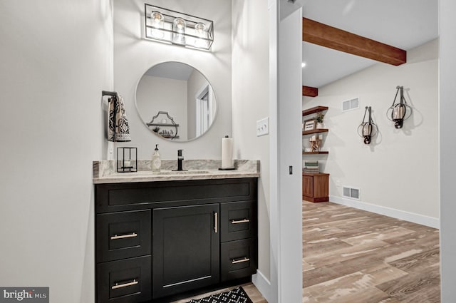 bathroom featuring beam ceiling, vanity, and hardwood / wood-style flooring