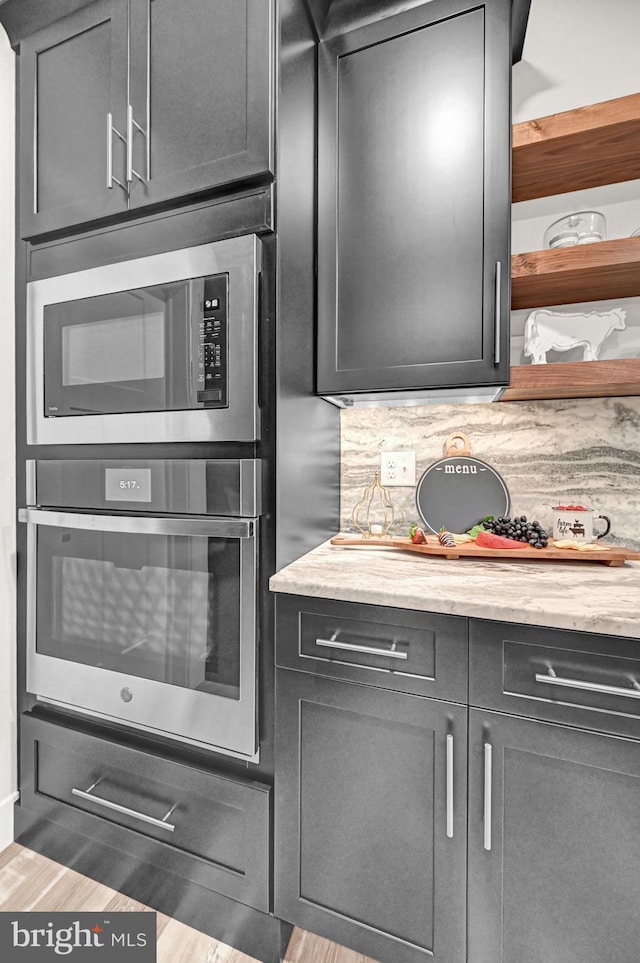 kitchen with appliances with stainless steel finishes, tasteful backsplash, and butcher block counters