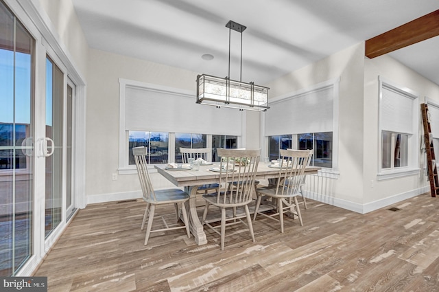 dining room featuring beamed ceiling and hardwood / wood-style flooring