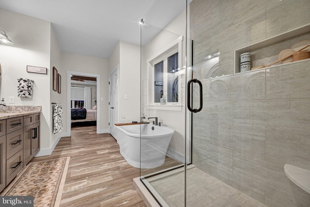 bathroom featuring vanity, independent shower and bath, and hardwood / wood-style flooring