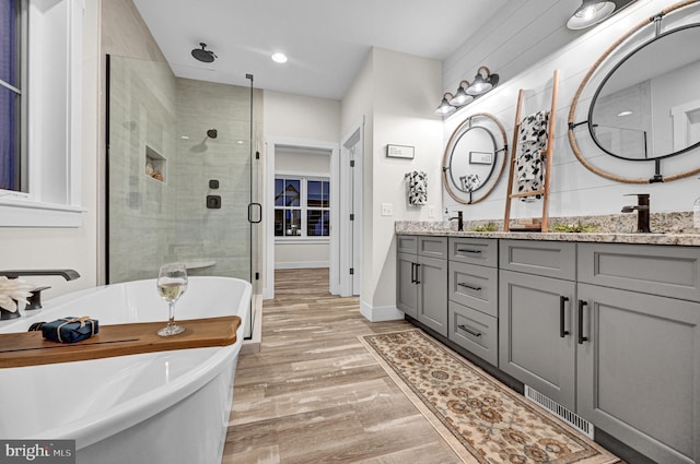 bathroom featuring hardwood / wood-style flooring, vanity, and independent shower and bath