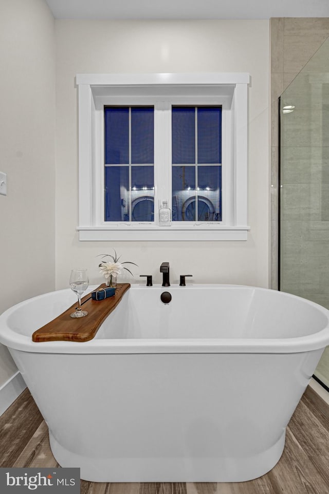 bathroom with hardwood / wood-style flooring and a washtub