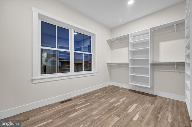 spacious closet with hardwood / wood-style flooring