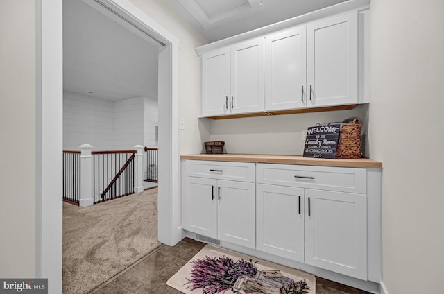 interior space with dark colored carpet and white cabinetry