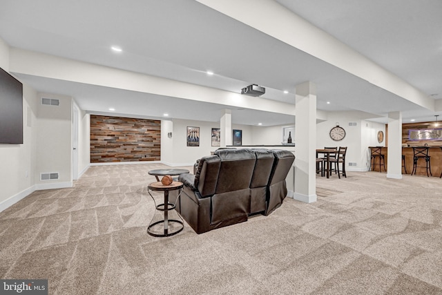 carpeted living room featuring wood walls