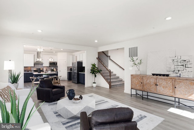 living room featuring an inviting chandelier and light wood-type flooring