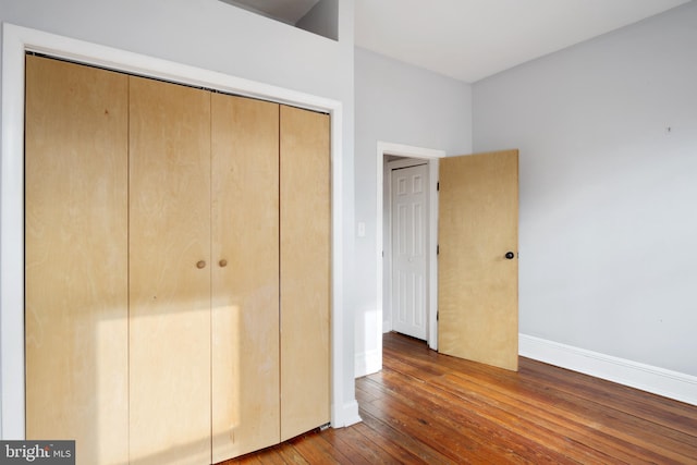 unfurnished bedroom with hardwood / wood-style floors and a closet